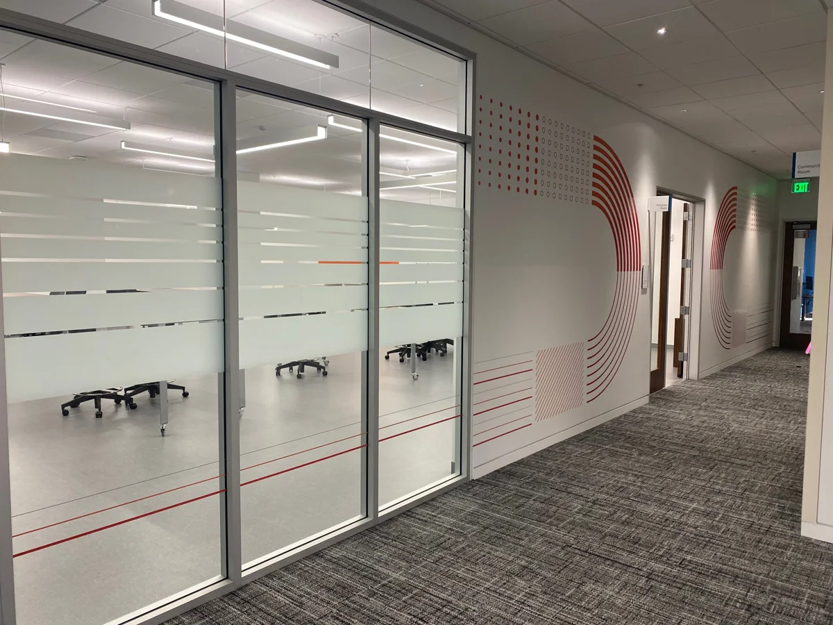 Frosted graphic bands across glass conference room walls at Genentech